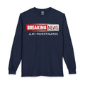 A navy blue long-sleeve t-shirt with a 'BREAKING NEWS' graphic on the chest. The graphic features a red and white banner with 'BREAKING NEWS' in white text, and 'JLR INVESTIGATES' printed in white below it.