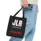 Lifestyle image of a person carrying a black JLR© Investigates tote bag with a white logo and red “BREAKING NEWS!” graphic.