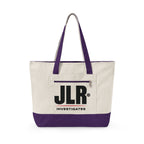 A canvas tote bag with an off-white body, purple handles and bottom trim, and a large black 'JLR INVESTIGATES' logo on the front pocket, shown on a plain white background.