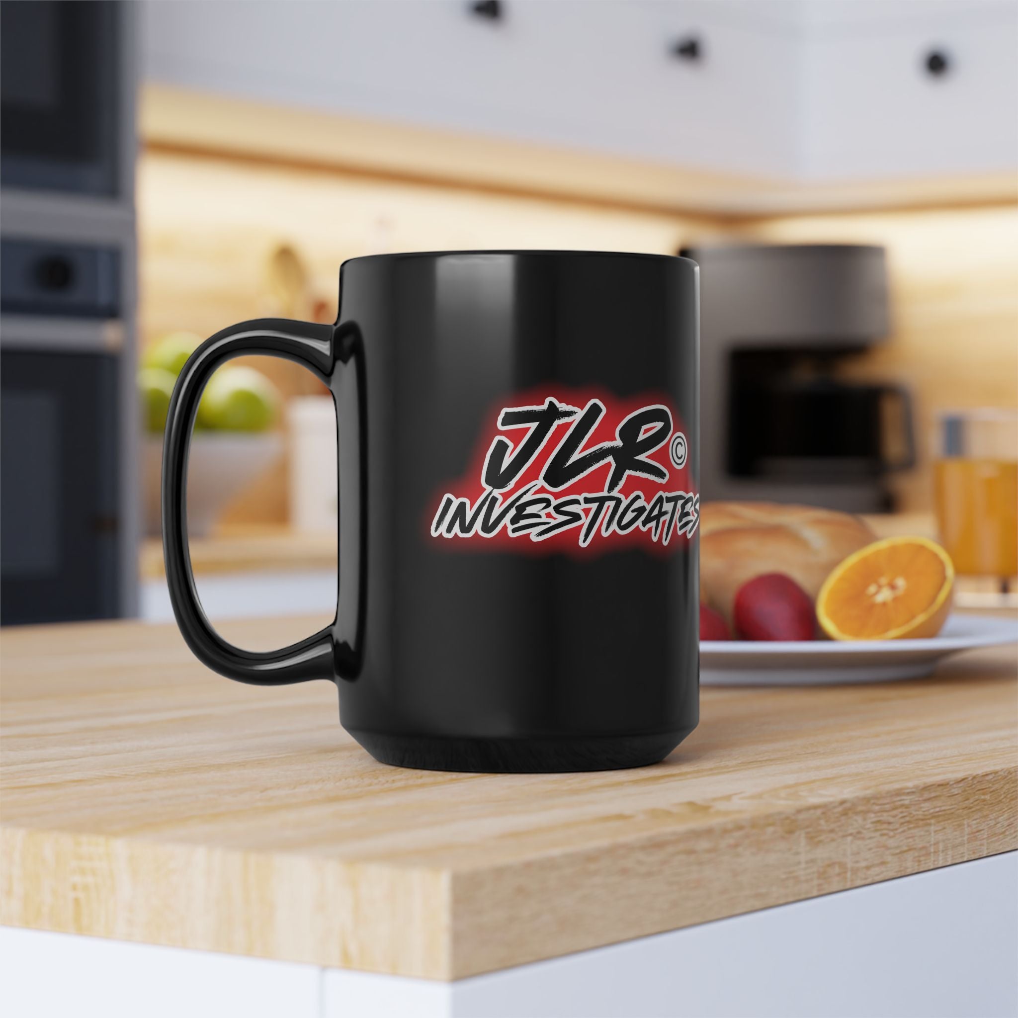 JLR Investigates branded 15oz black ceramic mug with bold red and white logo on kitchen counter— JLR Investigates