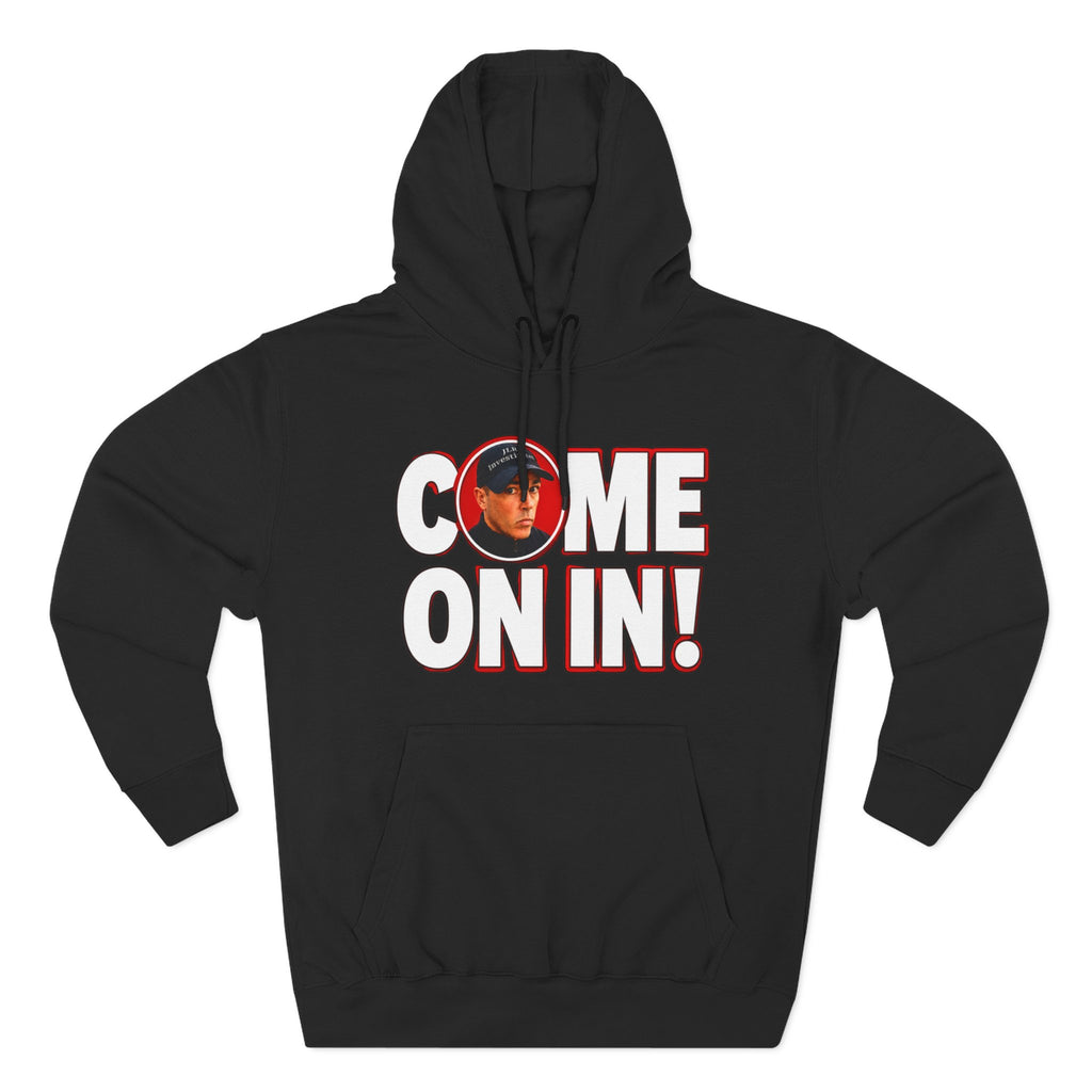 Black pullover hoodie featuring bold white 'COME ON IN!' text with a circular photo graphic replacing the letter O, printed on the chest