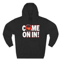 Black pullover hoodie featuring bold white 'COME ON IN!' text with a circular photo graphic replacing the letter O, printed on the chest