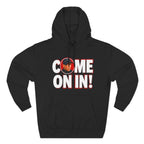 Black pullover hoodie featuring bold white 'COME ON IN!' text with a circular photo graphic replacing the letter O, printed on the chest