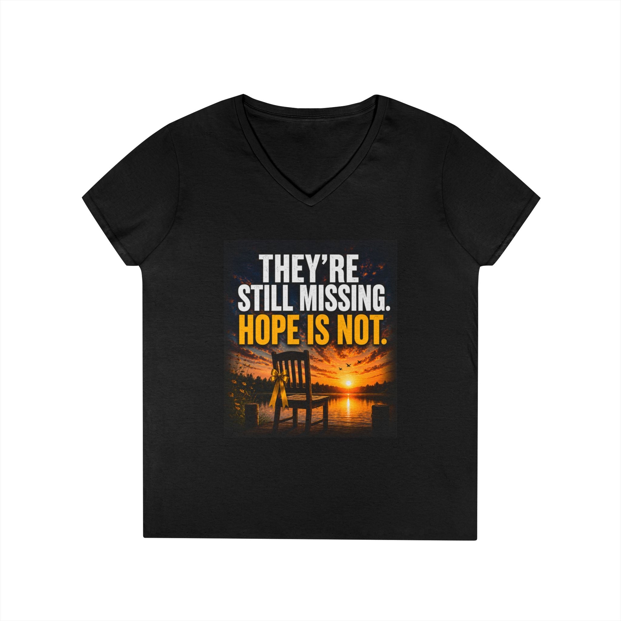 A black women's V-neck t-shirt with a graphic print on the front. The graphic features a sunset over water with an Adirondack chair, and the text 'THEY'RE STILL MISSING.