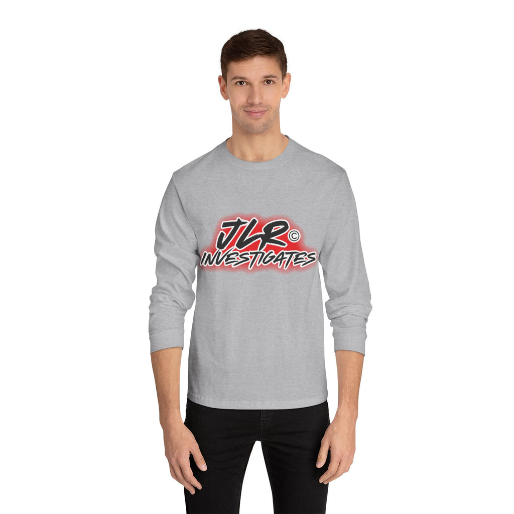 Man wearing grey long sleeve unisex t-shirt featuring bold 'JLR© Investigates' graffiti-style logo in red, white, and black.