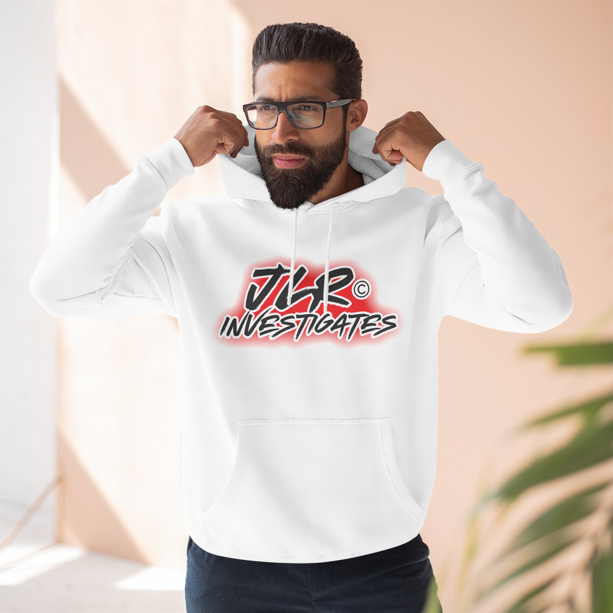 Man wearing JLR© Bold Logo Hoodie in White — graffiti-style JLR Investigates graphic on a pullover hoodie with kangaroo pocket and adjustable drawstring hood