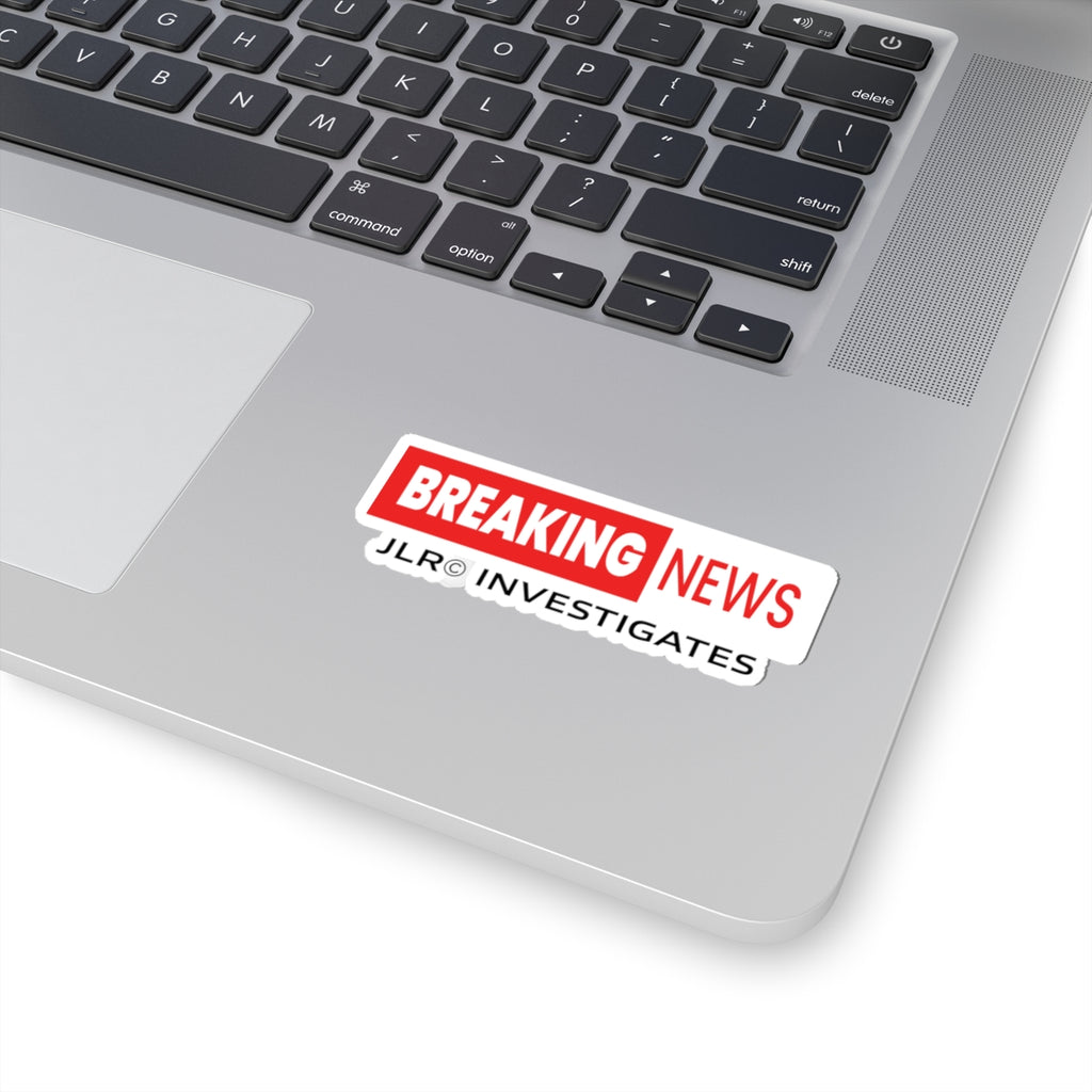 Breaking News JLR© Investigates sticker applied to a laptop keyboard, showing red and white design