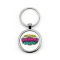 A silver metal round keychain with a printed graphic that reads 'JUST ANOTHER WHACKADOBLE WEDNESDAY!' in colorful comic-style lettering, shown on a plain white background.