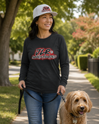 Woman walking a dog on a leash in a park-like setting wearing a black long-sleeve shirt with a JLR Investigates logo and a white cap.
