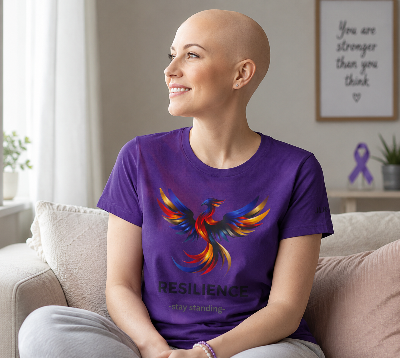 bald woman wearing purple unisex t-shirt featuring a bold multicolor phoenix rising graphic with the word RESILIENCE and tagline 'Stay Standing' — JLR Investigates apparel