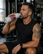 man in gym with JLR Investigates 20oz insulated water bottle — bold red and black JLR Investigates graffiti-style graphic — white stainless steel — JLR Investigates
