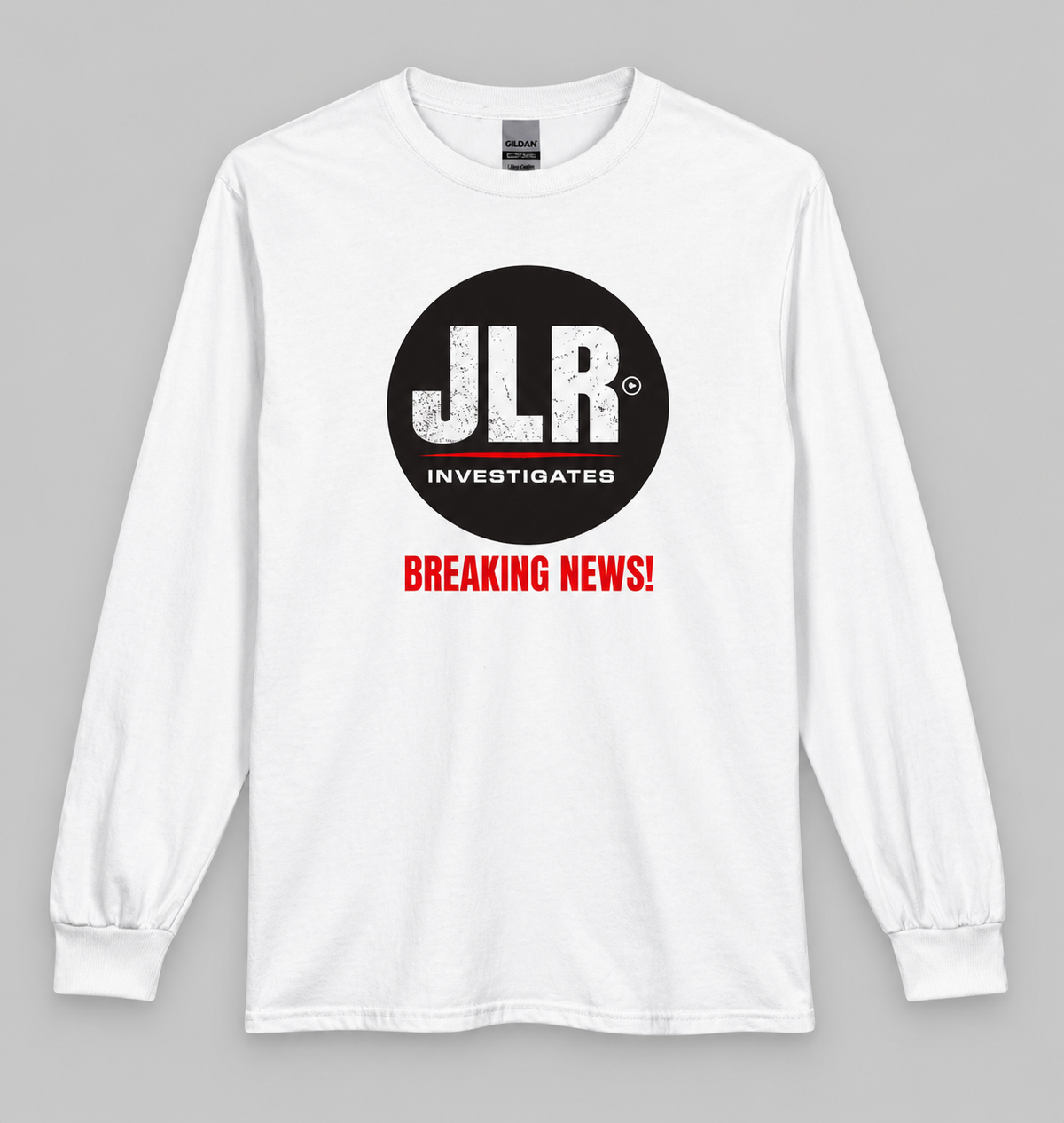 White long-sleeve shirt featuring the JLR© Investigates logo and red “BREAKING NEWS!” graphic, displayed front-facing on a light grey background.