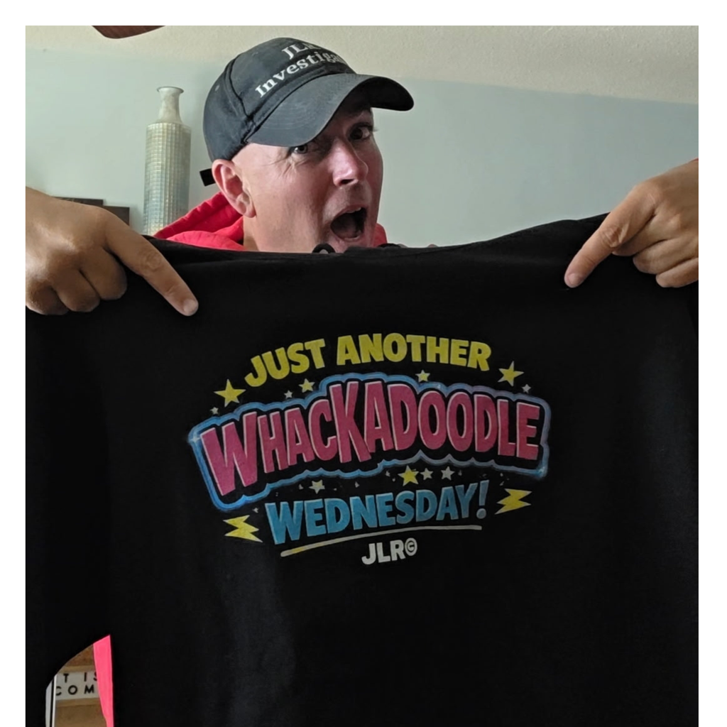 Person holding a black t-shirt with colorful text and logo