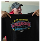 Person holding a black t-shirt with colorful text and logo