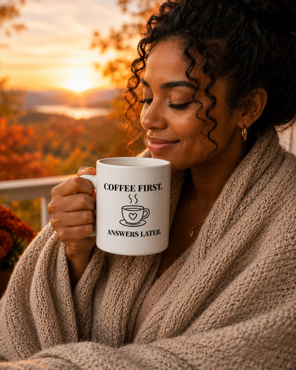 Woman holding a mug with 'Coffee First, Answers Later' text against a scenic background
