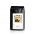 Black coffee bag with 'Boots on the Grounds' label featuring a coffee cup and boots illustration on a white background.