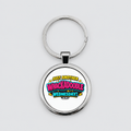 A silver metal round keychain with a printed graphic that reads 'JUST ANOTHER WHACKADOBLE WEDNESDAY!' in colorful comic-style lettering, shown on a light grey background.